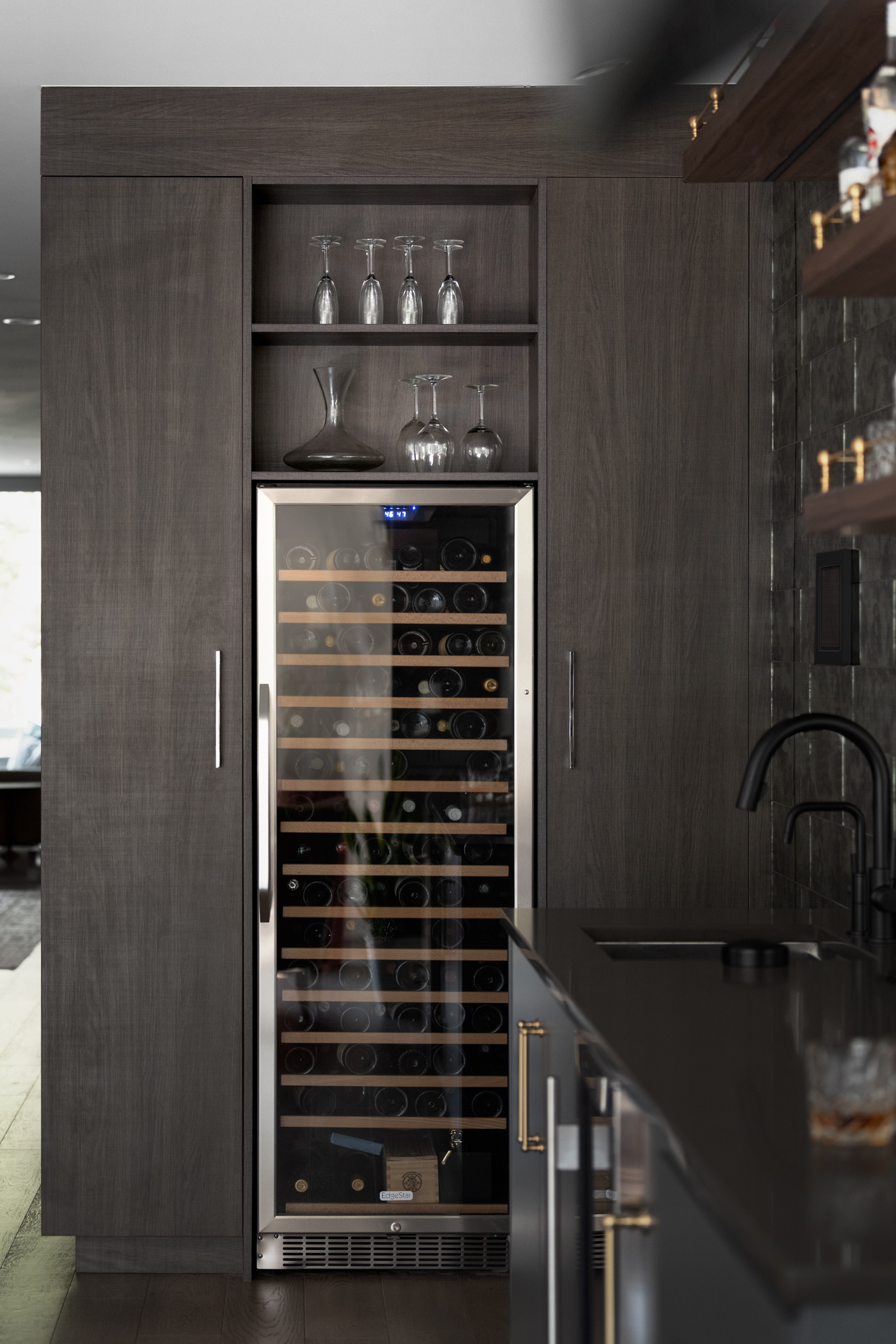 Wine refrigerator and dark wood cabinetry